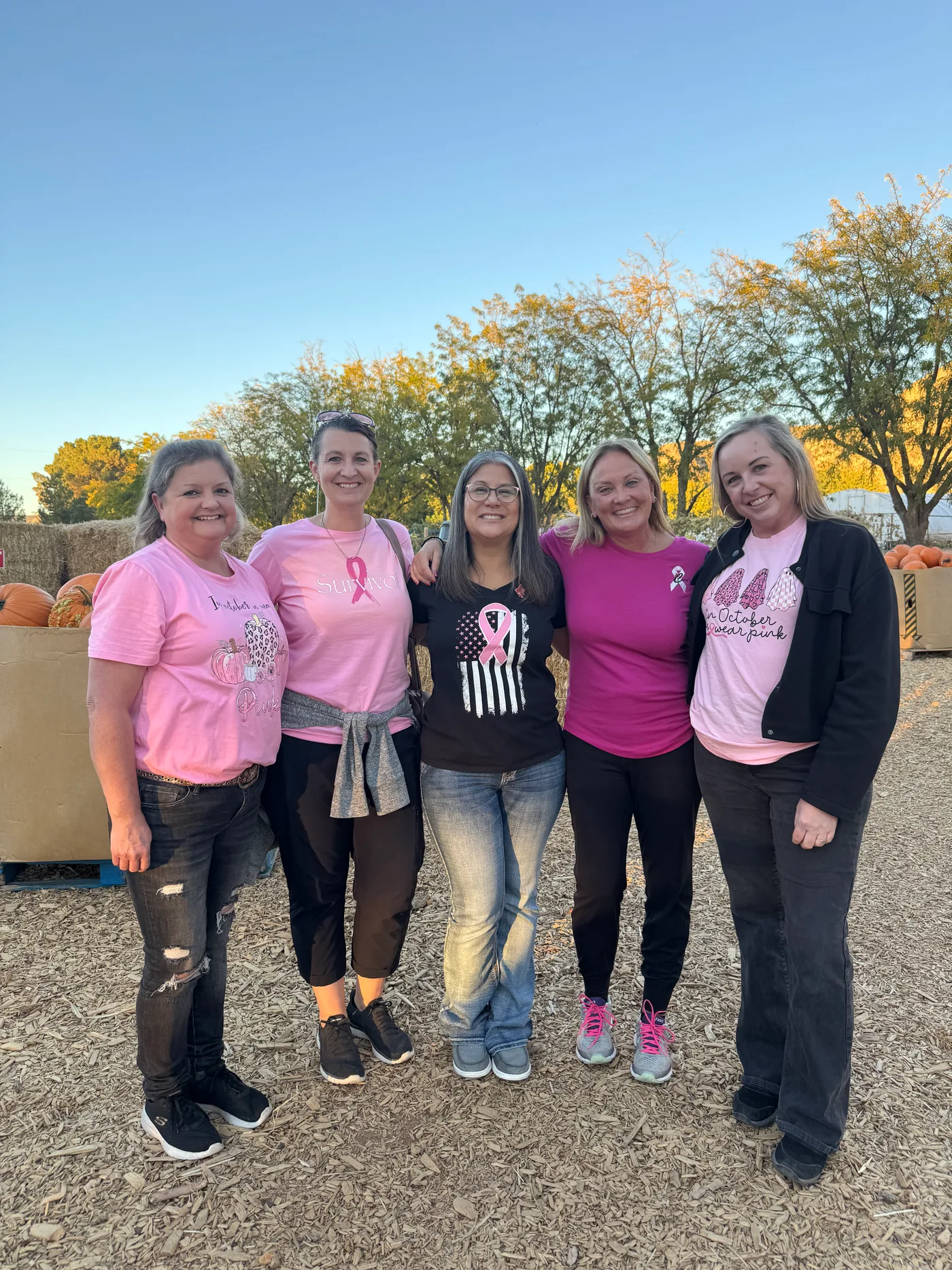 Jen with a group of breast cancer survivors at a community event, all wearing pink